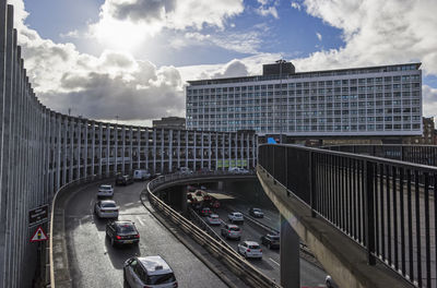 Cars on bridge in city against sky