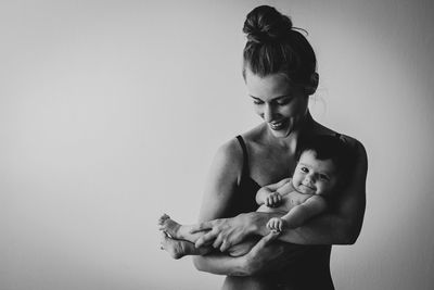 Black and white portrait of young mother holding her baby