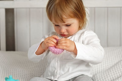 Baby girl playing tactile knobby balls. young child hand plays sensory massage ball