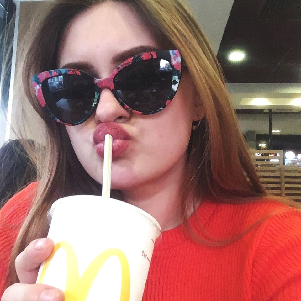 PORTRAIT OF A WOMAN DRINKING WATER FROM SUNGLASSES