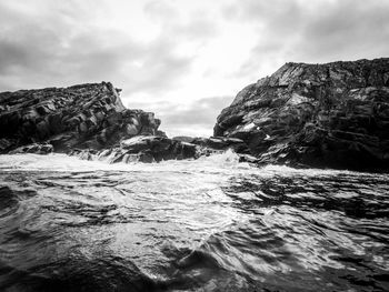 Black and white photo of waves agains rocks in antarctica