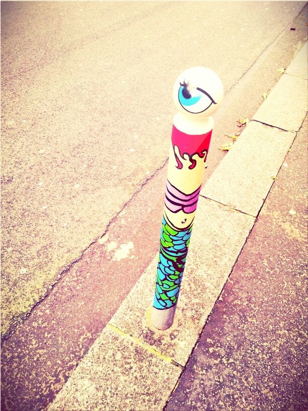 street, high angle view, multi colored, day, shadow, still life, sunlight, sidewalk, outdoors, childhood, blue, road, asphalt, paint, footpath, close-up, no people, striped, plastic, shoe