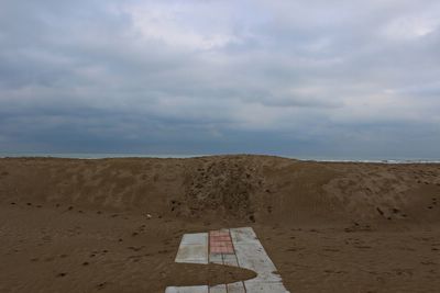 View of desert against cloudy sky