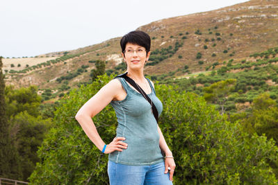 Portrait of smiling young woman standing on mountain