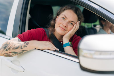 Portrait of smiling young woman in car