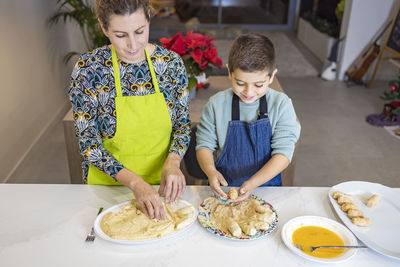 Mother and son making croquettes in the kitchen