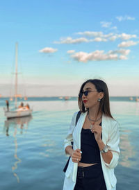 Young woman looking at sea against sky