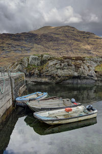 Boat moored in lake against sky