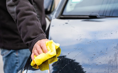 Midsection of man working in car