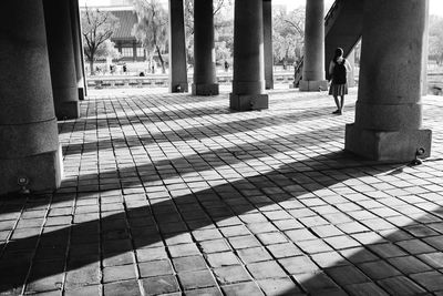 Woman standing on footpath in city