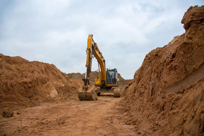 Excavator digs a large trench for pipe laying. backhoe during earthmoving at construction site. 