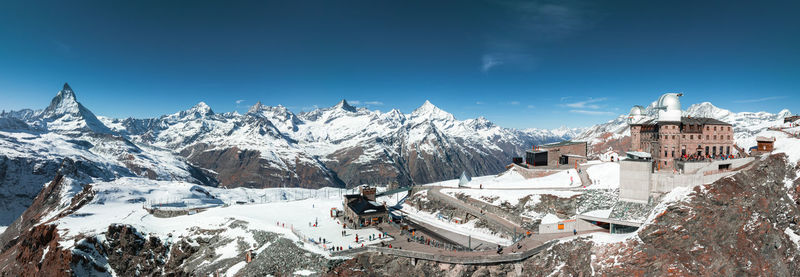 Scenic view of snowcapped mountains against blue sky