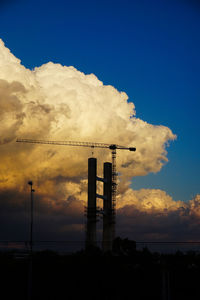 Silhouette smoke stack against sky at sunset