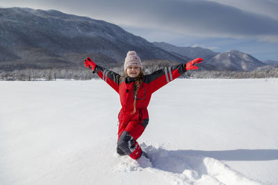 Young girl is having winter fun on a snowy, sunny day in lika, croatia