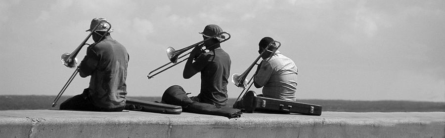 Men sitting on floor against sky