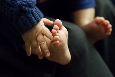 Cropped image of baby girl sitting on father lap