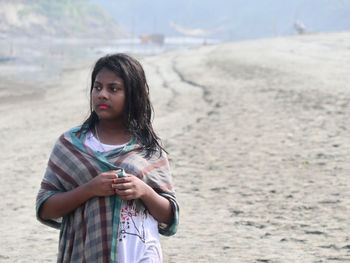 Young woman standing at beach