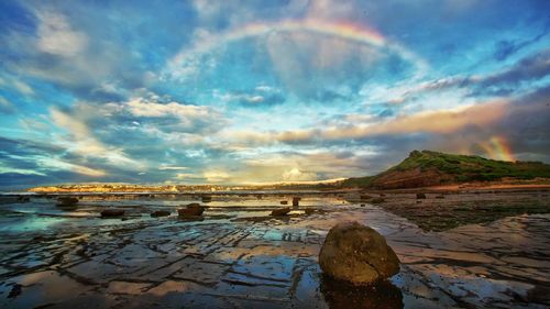 Scenic view of river against cloudy sky