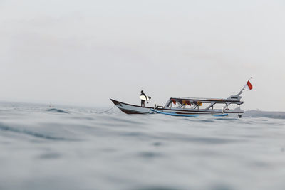 People in boat on sea against sky