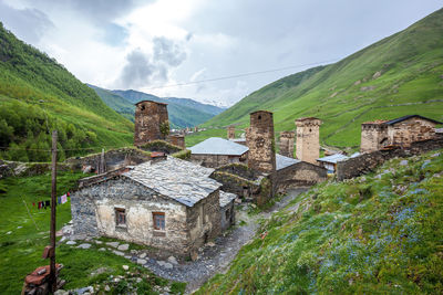 Old building by mountain against sky