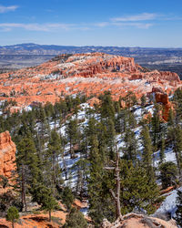 Scenic view of trees and mountains against sky