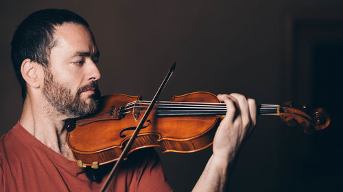 Midsection of man playing guitar