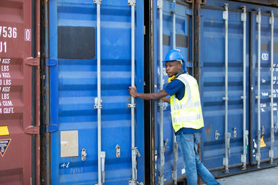 Rear view of manual worker closing cargo container