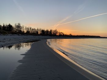 Scenic view of beach against sky during sunset