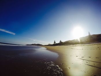 Scenic view of beach against blue sky