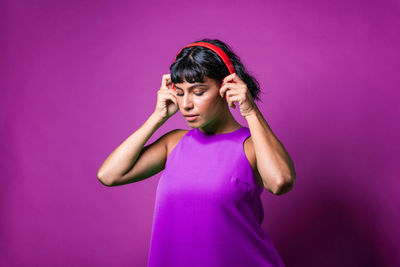 Young caucasian girl listens to music, wearing red music headphones.