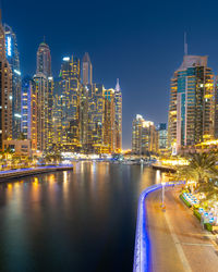 Dubai marina night scene with glowing skyline and calm water reflections