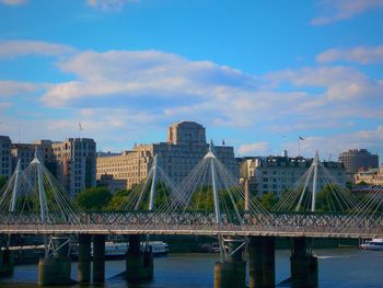 Bridge over thames river against sky in city