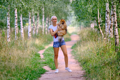 Full length of smiling woman on footpath