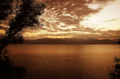 Scenic view of beach against dramatic sky