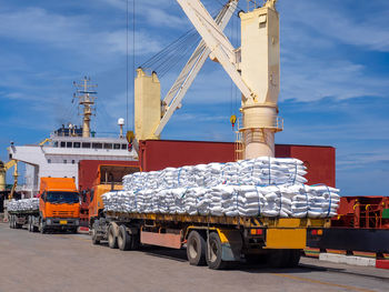 Sugar bags are loading in hold of bulk-vessel at industrial port.