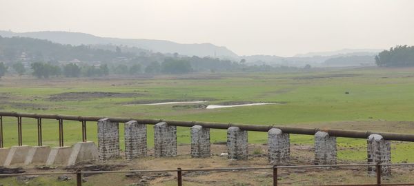 Fence on field against sky