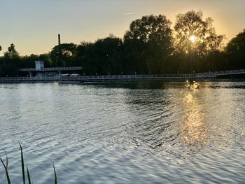 Scenic view of lake against sky at sunset