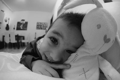 Portrait of cute boy lying on bed at home