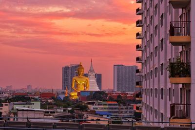 Buildings in city against sky during sunset