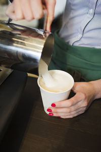 Woman pouring drink, close-up