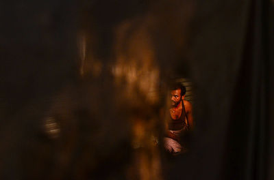 Portrait of young woman standing in mirror