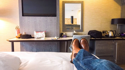 Low section of person relaxing on table at home