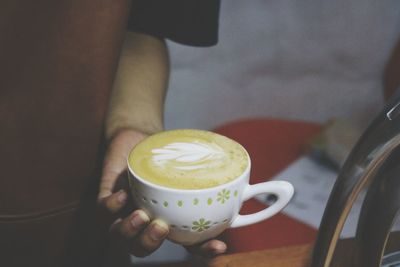 Midsection of man holding coffee cup