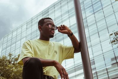 Low angle view of young man standing against building