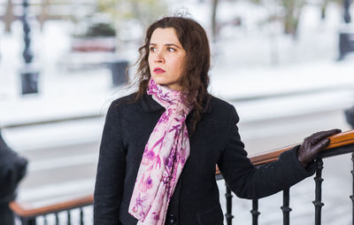 Portrait of young woman standing in city