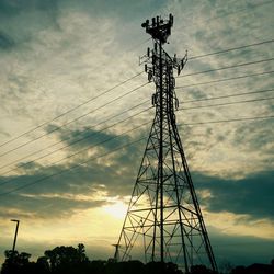 Low angle view of power lines against cloudy sky