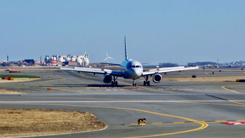 Airplane on runway against clear sky