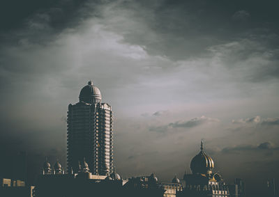 Low angle view of buildings against cloudy sky