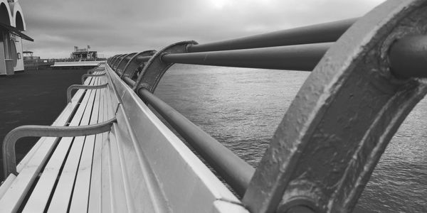 Close-up of metallic bridge against sky