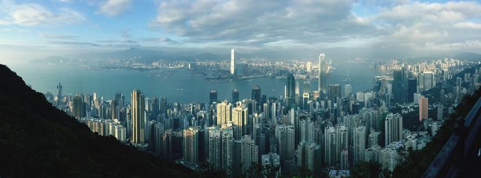 Panoramic view of city buildings against cloudy sky